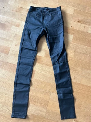 Svarta skinny jeans med stretch - Snygga svarta skinny jeans med klassisk femficksdesign och smal passform. Jeansen har normal midja och är tillverkade i ett stretchigt material som ger en bekväm känsla. Perfekta för dig som gillar en tight siluett och stilren look.
