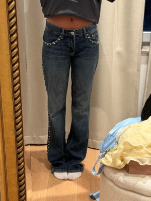 Mörkblå jeans med nitar - Snygga mörkblå jeans med nitar på sidorna och fram och bak ficka! Low waist och perfekt baggy. Lite fransiga där nere men syns knappast 