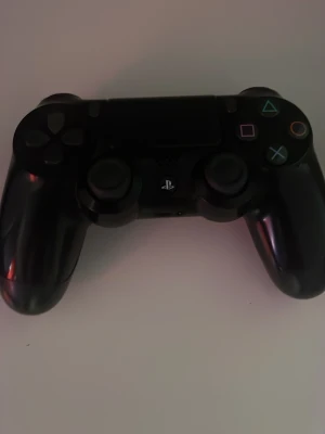 Svart PlayStation 4 DualShock handkontroll - Säljer en svart PlayStation 4 DualShock handkontroll från Sony. Den har klassisk design med två analoga spakar, styrkors, touchpad och färgade symbolknappar. Tillverkad i plast och passar perfekt för gaming på PS4.