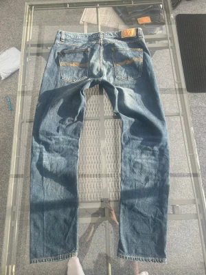 Nudie Jeans Lean Dean Deep Ocean – Clean Denim W33 L32 - Säljer ett par clean Nudie Jeans Lean Dean i färgen Deep Ocean. Snygg mörkblå wash med vintage känsla och slim tapered fit som sitter riktigt bra. Perfekta till streetwear, casual och clean outfits med hoodie, stickat eller sneakers.  Mycket Bra skick och sköna tack vare lite stretch i materialet. Stilrena premium denim jeans som funkar året runt och är lätta att matcha.  W33 L32 99% bomull, 1% elastane