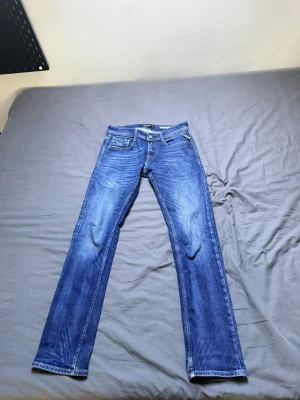 Blå regular jeans från replay.  - Säljer ett par klassiska blå jeans från replay med normal passform och fem fickor. Jeansen har snygga skontrastsömmar. Perfekta till vardagslooken och tillverkade i slitstarkt denimtyg.