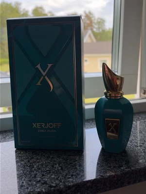 Xerjoff Erba Pura Eau de Parfum drygt 35-40 ml kvar  - Lyxig parfym från Xerjoff, Erba Pura, i en elegant turkos flaska med gulddetaljer och matchande förpackning. Flaskan har en unik form med guldfärgat lock och en metallplakett framtill. Innehåller 40 ml Eau de Parfum.