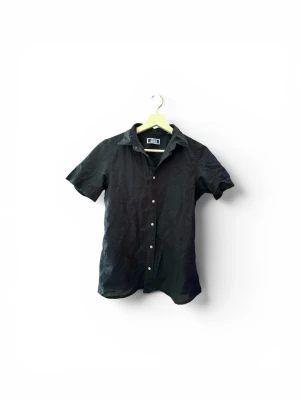Jack & Jones skjorta  - snygg mörkblå skjorta från Jack & Jones med vita knappar som ger en stilren och modern look. Passar perfekt till både jeans och linnebyxor 