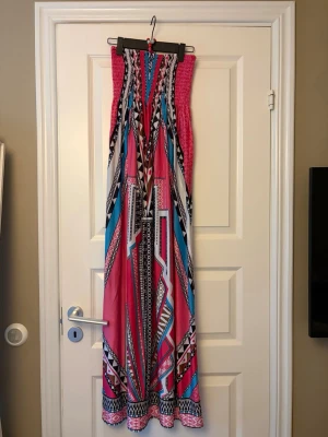 Lång bandåklänning  - Lång bandåklänning i storlek xxs/xs/s, passar dig som är 165 cm+. Aldrig använd. Från Spanien så okänt märke. Resor runt hela överdelen så den är mycket stretchig. Pris går att diskutera.