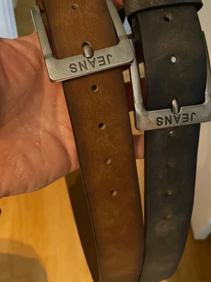 Nya Konstläder bälten - Två bälten som är helt nya och oanvända. Längd är 120cm och 110cm till mittenhålet 