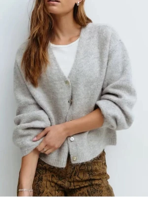 Ljusgrå oversized kofta med v-ringning - Mysig ljusgrå kofta med v-ringning och fyra knappar framtill. Koftan är stickad i ett fluffigt material och har en avslappnad, oversized passform med långa ärmar. 