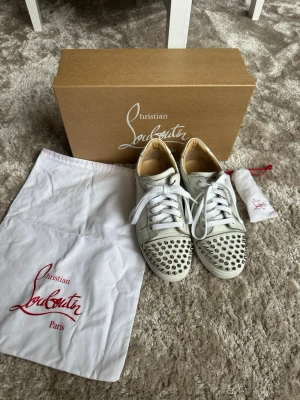 Christian Louboutin vita/silver skor Bianco  - Säljer mina Christian Louboutin skor då dom inte kommer till användning längre köpta för ungefär 1,5 år sen, de är inte så använda men man ser att de har slitits lite på vissa ställen. Modell Bianco. Har satt på nya skosnören och de tillkommer även ett par extra. Vid fler frågor eller funderingar är det bara att höra av sig!