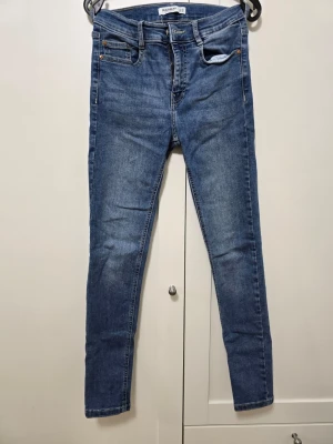 Två blå jeans från Pull&Bear- en tröja på köpet - Säljer 2 par klassiska blå skinny jeans från Pull&Bear. Materialet är stretchigt denim som sitter tajt längs benen. Du får en tröja på köpet i storlek S.                      Säljer allt för 70 kr 