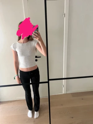 Vit croppad topp med öppen rygg - Snygg vit croppad topp med korta ärmar och öppen rygg som knyts med en rosett. Perfekt för dig som gillar trendiga och stilrena plagg. Enkel att matcha med både jeans och kjol.