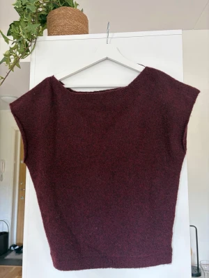 Stickad T-shirt tröja Nelly  - En vinröd/burgundy stickad T-shirt tröja från Nelly. Storlek S. Använd en gång så som ny. Båtringning i halsen. 