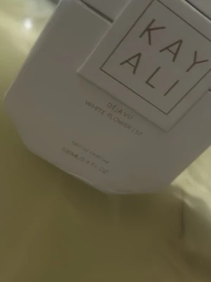 Kayali Déjà vu 57 100ml - En lyxig, feminin och exklusiv doft som är extremt svår att få tag på just nu.  Letar du efter en parfym som känns som ren elegans? Kayali Déjà Vu White Flower 57 är en av Kayalis mest ikoniska och eftertraktade dofter — och just nu är den slut hos flera återförsäljare, vilket gör denna flaska extra speciell.    Produktinfo: • 100 ml – full size • Köpt i Sverige • Perfekt som lyxig present