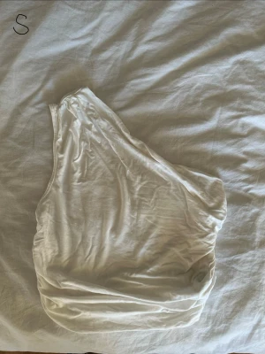 Vit oneshoulder topp i bomull - Snygg vit oneshoulder topp. Den är liiiite genomskinlig men så länge man har vitt under funkar det!💗