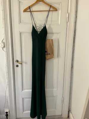 Balklänning - Säljer en mörkgrön, unik och jättefin glittrig/ skimrig balklänning med snygg rygg. Fin vid flera tillfällen men jag har endast använt den en gång. Köpt på Zalando strl S, strechig i materialet så kan även passa M. Knyt i ryggen för passform