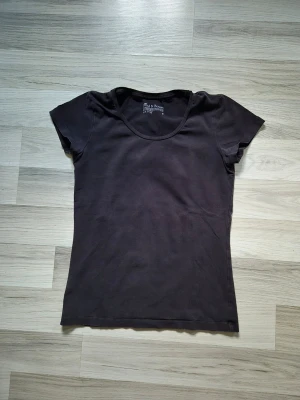 Svart basic t-shirt från Bread & Boxers - En enkel svart t-shirt från Bread & Boxers med rund halsringning och korta ärmar. Tillverkad i mjuk bomull för en bekväm känsla. Perfekt att matcha med jeans eller kjol för en clean och stilren look.