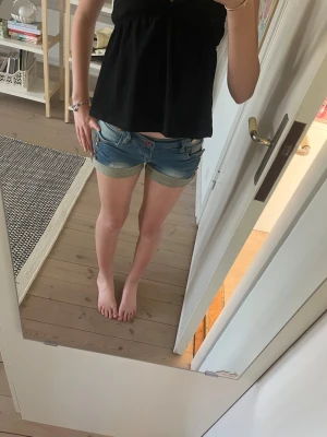 Blå denimshorts från monday premium  - Säljer ett par klassiska blå jeansshorts med uppvikta benslut och femficksmodell. Shortsen har låg midja och stängs med knapp och dragkedja. Perfekta till sommaren och lätta att matcha med olika toppar.