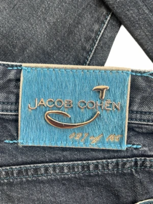 Selvedge Jacob Cohën J622 LTD – Limited Edition (Endast 105 ex!) - Jacob Cohën Selvage jeans i nyskick, otrolig premiumdenim. Limited edition, extremt sällsynta (nr 27 av 105). Använda minimalt, max 1-2 gånger, som nya. 📏 Storlek & Passform: Storlek 33.  Modellen är 190 cm & väger 80 kg.  🧩 Material: 98% bomull / 2% elastan 📐 Mått: Midja: 42,5 cm Längd: 109 cm Benslut: 18 cm Lår (från grenen): 26,5 cm ✅ Skick: 10/10 ✨ Detaljer: Inbroderat ”Selvedge”. Exklusiv patch, citat & broderier.  💰 Nypris: Ungefär 8000 kr ‼️Skickas snabbt‼️Skriv om det önskas fler bilder!