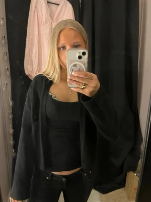 Svart kofta - Fin stickad tröja från Gina Tricot. Finns en knapp i kanten längst upp ifall man vill stänga den! Knappt använd!