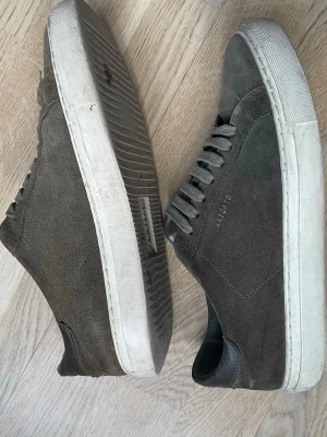 Arigato sneakers - Hej, jag säljer ett par arigato mocka skor i brun/mörkgrön färg och i storlek 39. De är i ganska bra skick kan behövas tvättas lite bara, annars är de sköna och snygga. Hör gärna av er om ni vill ha fler bilder på skorna eller har frågor😊