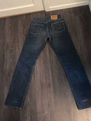 Levi's 501 blå jeans - Klassiska Levi's 501 jeans i mörkblå denim. Storlek w30 L34, lite skav längst ner som syns på bilderna som skapats då de har varit uppvikta