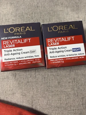 L'Oréal Revitalift Laser dag & nattkräm - Revitalift Laser Triple Action Anti-Ageing Cream från L'Oréal Paris. Ett set med dag- och nattkräm som innehåller pro-retinol, hyaluronsyra, vitamin Cg och argireline peptid. Förpackningarna är röda och svarta med vita detaljer.