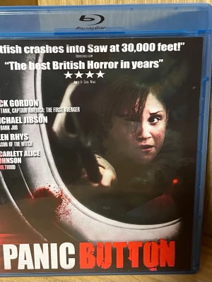Panic Button Blu-ray thriller - Säljer filmen Panic Button på Blu-ray, en brittisk thriller om sociala nätverk och mörka hemligheter. Omslaget har blodstänk och flygplansfönster, och filmen beskrivs som en intensiv skräckupplevelse. Text på engelska, svenska, norska och finska.
