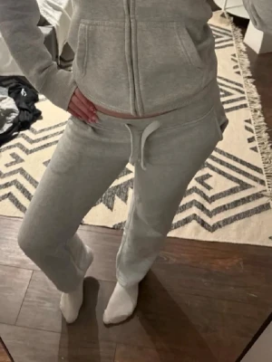Russemerch byxor - Säljer ett par grå mjukisbyxor från Russemerch. Byxorna har fickor på sidorna och är gjorda i mjukt sweatshirtmaterial, perfekta för chill dagar. Passar dig som gillar en avslappnad och enkel stil.