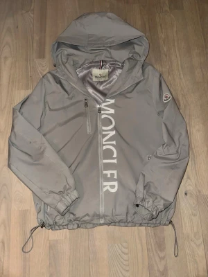 Moncler jacka  - Grå Moncler windbreaker perfekt för våren och sommaren, bra för blåsiga dagar eller en sommar dag, skriv vid intresse. Storlek M
