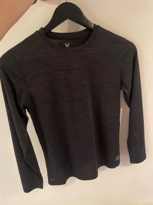 Träningströja - Säljer en svart långärmad träningströja från soc. Lite för liten för mig så aldrig använt den stav säljer jag. Inga defekter superskönt material och skulle säga att den sitter som en xs/xxs💕