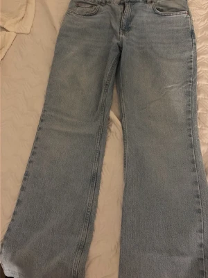 Ljusblåa raka jeans från Gina Tricot - Säljer ett par ljusblåa jeans från Gina Tricot med rak passform och hög midja. Jeansen har klassisk femficksdesign och är tillverkade i ett mjukt denimtyg. Perfekta för en avslappnad och trendig look.