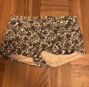 Blommiga shorts från H&M - Snygga blommiga shorts från H&M i svartvitt mönster. De har en låg midja och är tillverkade i ett mjukt bomullsmaterial. Perfekta för varma dagar! 💙