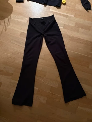 Svarta kostymbyxor  - Säljer mina svarta kostymbyxor som är lowwaist och lite utsvängda med väldigt fina fickor. Dom är 85cm inerbenslängd och har 37cm i midjan. 