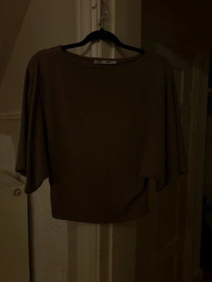 Beige topp från 157 med vida ärmar - Säljer en enkel och stilren beige topp från 157. Toppen har rund halsringning och vida, lösa ärmar. Löser upptill och formad vid midjan💕 Inte använd mycket
