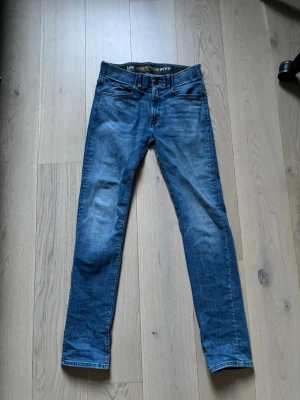 Blå jeans - Säljer ett par blå slim fit jeans från Lee med klassisk femficksmodell och snygg tvättad look. Jeansen har normal midja, dragkedjegylf och Lee-logga på bakfickan. Tillverkade i mjuk denim med lite stretch för extra komfort.