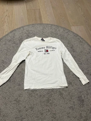 Vit långärmad topp Tommy Hilfiger - Vit långärmad topp från Tommy Hilfiger, tröjan är i storlek 164 så skulle säga XS, den är också väldigt bra skick