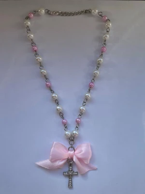 Pärlhalsband med kors - Pärlhalsband med silverfärgat kors och rosett, gjord av rostfritt stål (304) av mig💕
