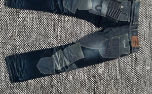 Patchwork jeans från Japrag  - Unika mörkblå patchwork jeans från japrag med flera olika former fickor i olika nyanser av denim. Snygga detaljer som broderade loggor och kontrastsömmar. Raka ben och klassisk femficksmodell, perfekta för dig som vill sticka ut.