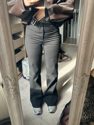 Svarta utsvängda kostymbyxor Zara - Snygga svarta kostymbyxor med hög midja och utsvängda ben. Byxorna har en klassisk look och sitter tight upptill för en modern siluett. Perfekta att styla med sneakers eller boots. Från Zara helt nya prislapp storlek S 