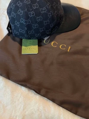 Svart keps  - Snygg svart keps. Justerbar rem bak och böjd skärm i svart. Tillverkad i slitstarkt tyg och levereras med original dustbag och tagg. Perfekt för dig som vill ha en exklusiv och trendig accessoar.