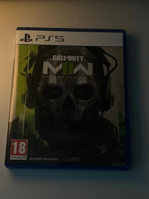 PS5 Call of Duty: Modern Warfare II - Säljer Call of Duty: Modern Warfare II till PS5. Spelet kommer i ett blått plastfodral med omslag i svart, grönt och vitt. PEGI 18-märkt. Perfekt för dig som gillar action, multiplayer och special ops-lägen.