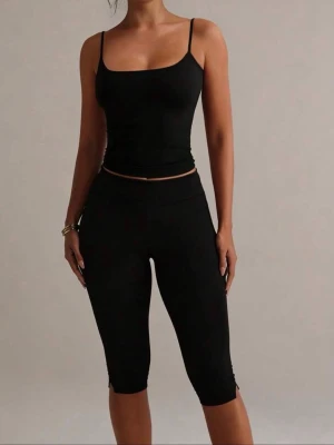 Svarta capri pants - Säljer ett par svarta capripants med medelhög midja och liten slits vid benslutet. De är stretchiga och sitter tight, materialet är i träningstights, därav varför jag säljer.🌸Strl s men passar även M