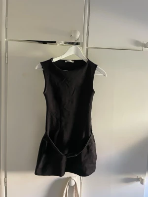 Svart populär ärmlös kort klänning - Säljer en svart, ärmlös kort klänning med enkel och stilren design. Klänningen har rund halsringning och markerad midja. Perfekt för dig som gillar minimalistisk stil och vill ha något som funkar till många olika looks. Från Zara!!! För kort på mig som är 179 med lång överkropp