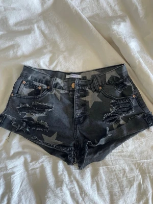 Grå stjärnmönstrade jeansshorts - Snygga grå jeansshorts från Glamorus med stora vita stjärnor och slitna detaljer framtill och baktill.   Shortsen är lågmidjade 🤍