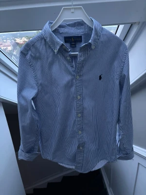 Randig Ralph Lauren skjorta  - Otroligt snygg randig skjorta från Ralph lauren, perfekt nu inför sommaren🤩 sparsamt använd knappt några täcken på användning. Storlek 14 i barnstorlek, skulle säga att den passar en xxs . Pris 399 😍✅ skriv vid minsta fundering // Noel 