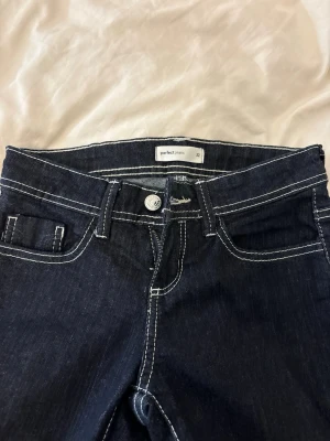 Mörkblå jeans från Perfect Jeans - Snygga mörkblå jeans från Perfect Jeans med kontrasterande vita sömmar och klassisk femficksmodell. Jeansen har normal midja och raka ben, perfekta för en stilren och enkel look. Materialet är slitstarkt denim som håller länge.