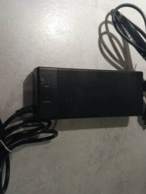 Svart laddare till Elsparkcykel & Elcykel 42V  - Elektronisk laddare till elcykel och Elspark cykel xiaomi av känt märke, svart plast med räfflad yta. Märkt med 42V 2A output och har EU-kontakt. Passar till batterier på 36V. Kabeln är fastmonterad och laddaren har tydliga etiketter med info.