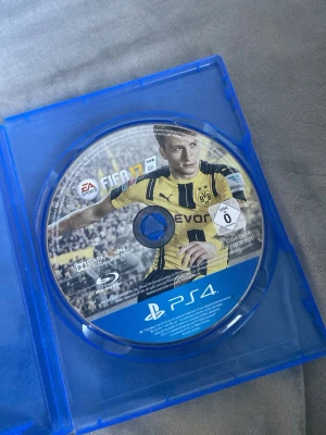 FIFA 17 till PS4 - FIFA 17 till PlayStation 4 i blå plastfodral. Spelet har ett sportigt omslag med fotbollstema och är utvecklat av EA Sports. Perfekt för dig som gillar fotbollsspel och vill utmana vänner på matcher, ni som vill ha när messi kör i barca osv kan spela här.