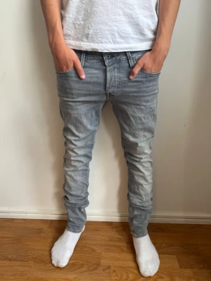Ljusgrå slim fit jeans från jack&jones  - Säljer ett par ljusgrå slim fit jeans från jack&jones med klassisk femficksdesign och normal midja. Jeansen har en snygg tvättad look och smala ben som sitter tajt hela vägen ner. Perfekta för dig som gillar en modern och avslappnad stil. Strl: W30 L32✅ Pris kan diskuteras!💸 Hör av dig om du har funderingar!👍