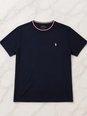 Mörkblå t-shirt från Polo Ralph Lauren - Klassisk mörkblå t-shirt från Polo Ralph Lauren med korta ärmar och rund halsringning med röd och vit kant. Ikoniska broderade loggan i vitt på bröstet. Tillverkad i mjuk bomull för en skön känsla. Och en grisch look. Vid frågor hör av er priset kan alltid diskuteras 