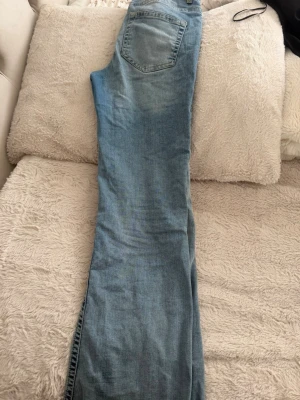 Ljusblå  bootcut jeans(ordinarie pris: 279kr) - Säljer ett par ljusblå jeans med fin passform och klassisk femficksdesign. Jeansen har en något tvättad look och är tillverkade i denim. Perfekta för en avslappnad stil.