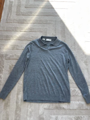 Långärmad piké tröja  - Snygg grå långärmad piké tröja i mjuk merinoull. Perfekt för en stilren och avslappnad look. Slim fit passar M och S. Använd 2 gånger. Pris kan diskuteras vid snabb affär😄
